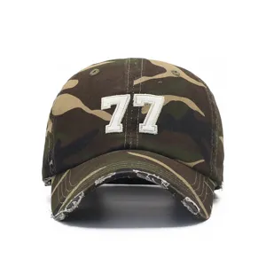Close-up detail of the vintage distressed camo baseball cap featuring white embroidered number 77.