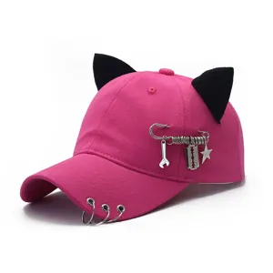 Detailansicht der pinken Baseballcap im Punk-Stil mit schwarzen Katzenohren und Metallringen.