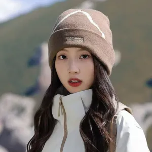 Close-up of brown outdoor knit beanie with snow mountain pattern and brand embroidery