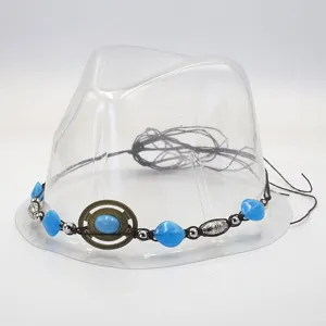 Close-up detail of vintage bohemian hat band accessory with blue beads and metal ring.