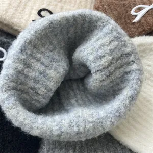 Close-up detail shot of fluffy knitted winter beanie, cozy woolen texture and warm fit.
