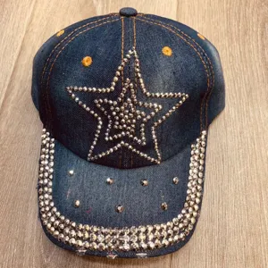 Close-up detail van strass sterversiering op de blauwe denim baseballpet en de rand van klep.