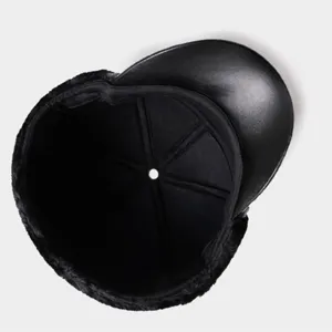 Detail view of the black leather winter cap, showing inner lining and brim craftsmanship.