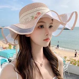Cappello di paglia da donna a tesa larga con bordo in pizzo e rete per estate e mare.