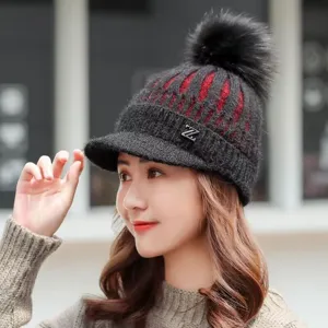 Winter knitted beanie hat detail view with pom pom, visor and warm fleece lining for cold weather.