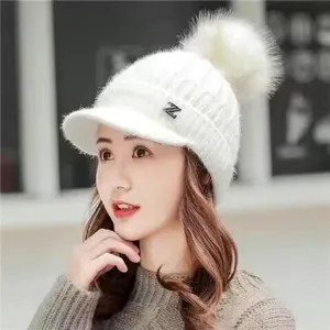 White knitted winter beanie hat for women with plush pom pom and metal Z logo detail warm.