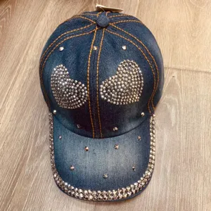 Gedetailleerd overzicht van de hippe denim baseballcap met sprankelende strass hartmotieven.
