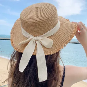 Detailed view of women's straw sun hat with white bow ribbon, breathable and stylish beach.