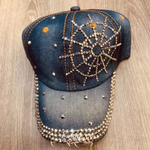 Donkerblauwe denim honkbalpet met fonkelend strass spinneweb design en versierde kleprand.