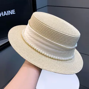 Eleganter Strohhut für Damen mit weißem Band und Perlenbesatz für Sommer und Sonnenschutz.