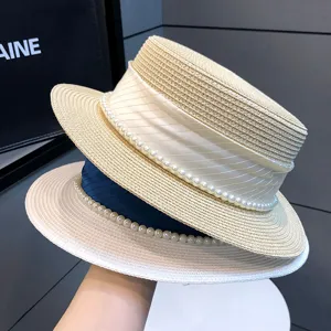 Nahaufnahme eines eleganten Damen-Strohhutes mit Perlen und Schleife für den Sommer.