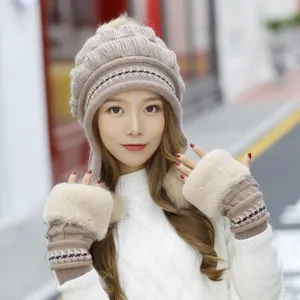 Close-up of model wearing a stylish beige winter knit earflap hat and fur-trimmed gloves