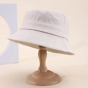 Closeup detail of the classic plain cotton bucket hat, showing the fine stitching and soft fabric texture.