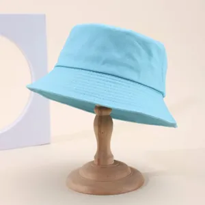 Close-up view of a classic light blue cotton bucket hat displayed on a wooden stand.