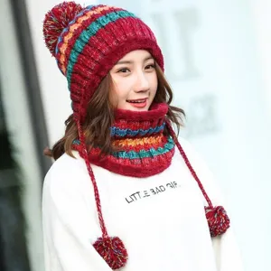 Detailed view of Asian model wearing a multi-color knit hat with three pom-poms.