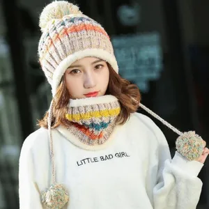 Detail view of women's warm knitted hat with three pom-poms and matching thick neck warmer