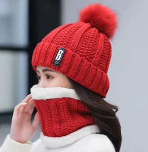 Cozy red knitted winter beanie and scarf set with cute pom-pom and warm fleece lining for cold days.