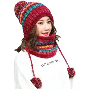 Colorful striped winter knit hat and scarf set with pom-poms for women.