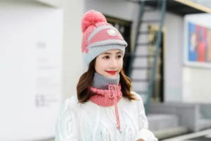 Winter knit hat detail view showing thick fleece lining, pom-pom design, and warm ear protection.
