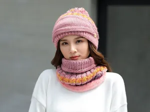Vista dettagliata di un cappello invernale caldo da donna con sciarpa coordinata rosa.
