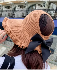 Women's knitted empty top sun hat with wide ruffled brim and stylish black bow for summer.