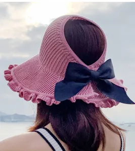 Detailed view of pink knitted empty top sun hat with black bow and large brim for summer outdoor.