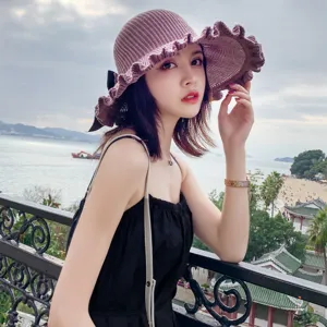 Women summer knitted sun hat with wide ruffle brim and black bow detail for outdoor travel.