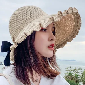 Beige knit empty top sun hat with wide brim and black bow, stylish summer outdoor beach hat for women.