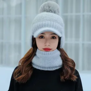 Gorro de punto de invierno gris con visera, orejeras y pompón, cuello a juego.