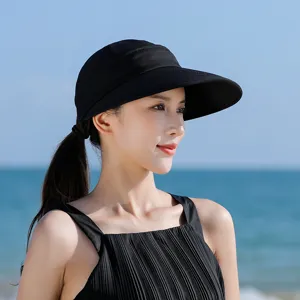 Close-up detail of women summer black sun visor hat, wide brim UV protection outdoor beach.