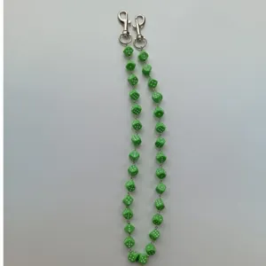 Green dice chain detail closeup, acrylic dice hip hop pants chain and bag strap accessory.