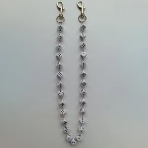 Closeup detail of a creative dice shaped pants chain and bag accessory, punk hip hop style.