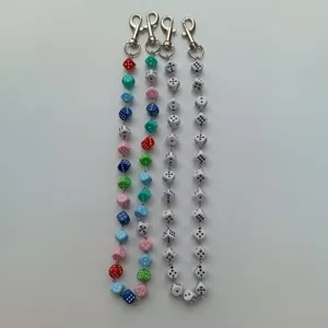 Detailed view of colorful and white dice keychain pants chains, trendy hip-hop bag accessories.