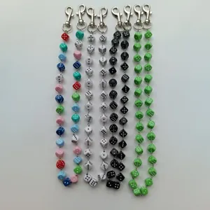 Detailed view of colorful acrylic dice pants chains with metal lobster clasps, hip-hop style.