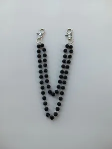 Detail view of a double-layered black rhinestone bead chain with silver lobster clasps