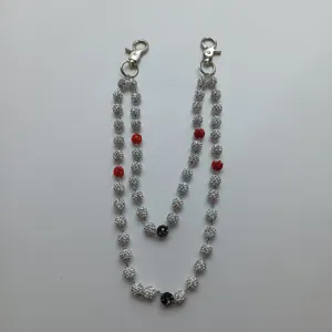 Close-up detail of 12mm white and red rhinestone disco ball beads on hip-hop trouser chain