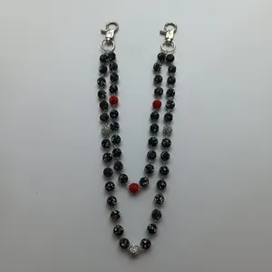 Macro view of 12mm black and red clay rhinestone ball chain for hip-hop jeans.