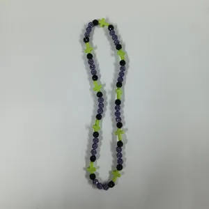 Green cross and purple rhinestone bead necklace detail, fashion jewelry accessory for daily wear.
