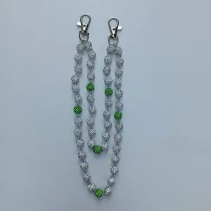 Macro detail of 12mm rhinestone disco ball hip hop pants chain with green accent beads