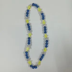 Detailed view of the colorful beaded cross necklace with sparkly crystal balls and elastic cord.