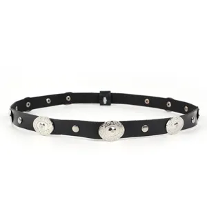 Detailopname van een zwarte etnische accessoireband met zilveren metalen studs en schijven.