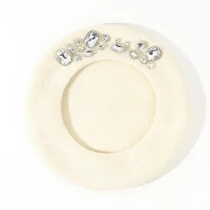 Close-up detail of the elegant beige wool beret featuring sparkly crystal rhinestone embellishments.