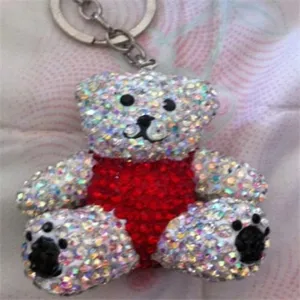 Detailed close-up of a sparkling rhinestone bear keychain with a red heart and silver ring.