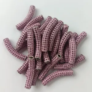 Nahaufnahme von rosafarbenen Strass-Bogenröhrchen, Tonperlen für DIY-Schmuckherstellung.