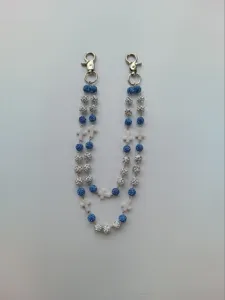 Detail of hip-hop pants chain featuring blue rhinestone beads and white cross charms.
