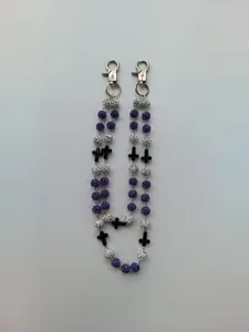 Detailed view of hip hop pant chain with purple rhinestone balls and black crosses