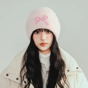 Pink knit beanie for women, cute bow decoration, warm winter knitted cap, cozy fashion hat.