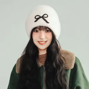 Women winter warm plush knitted beanie hat with cute black bow embroidery style casual.