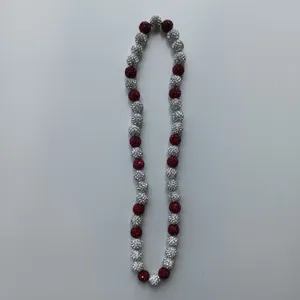Close-up view of the red and silver rhinestone clay bead necklace, showing sparkling crystal balls.