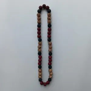 Close-up detail of sparkling rhinestone clay beads strand in red, black and bronze colors.
